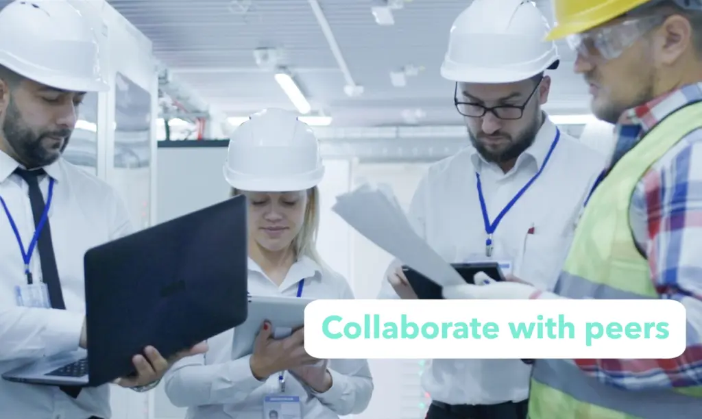 A group of people in hard hats and safety glasses collaborating around a computer displaying "collaborate with peers."